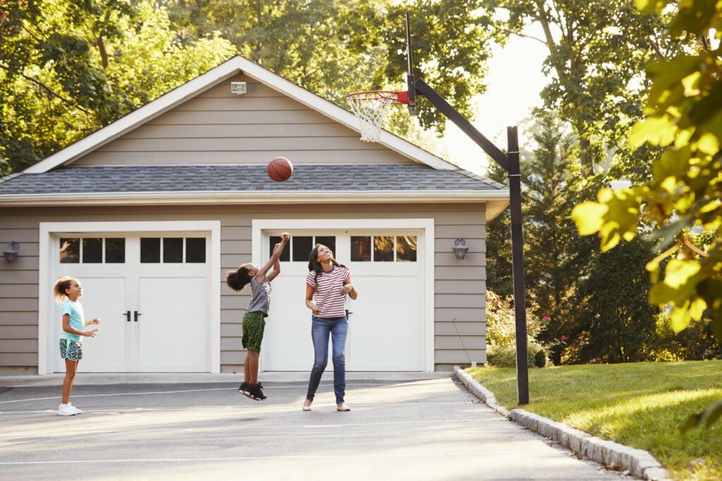 Mother And Children Playing Basketball On Driveway At Home in New Hampshire