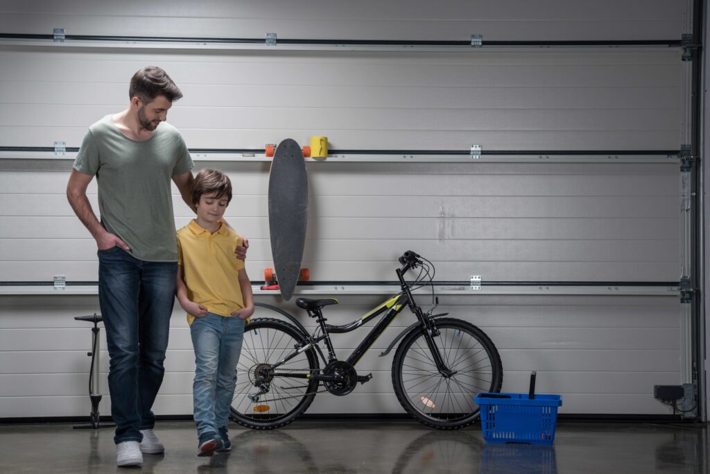 Smiling father and son standing together in New Hampshire Garage